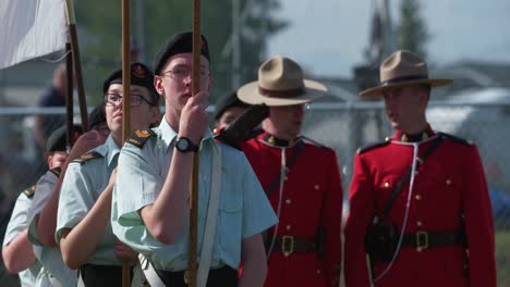 Canadian-army-cadets-hold-flags-with-RCMP-officers-in-background