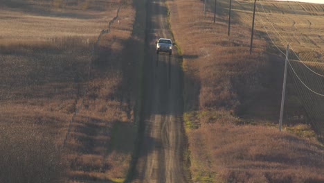 Long-shot-of-pickup-truck-driving-down-long-prairie-dir-road-towards-camera