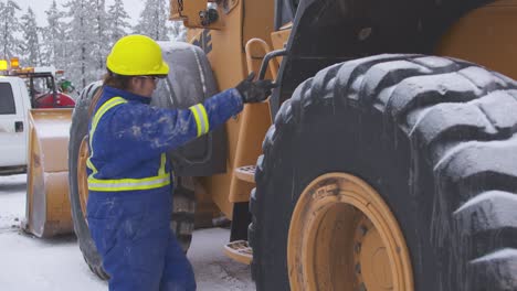 Female-heavy-equipment-operator-performs-thorough-inspection-of-loader-wide-shot