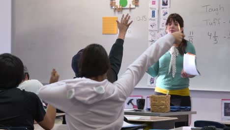 Students-raising-their-hands-in-classroom