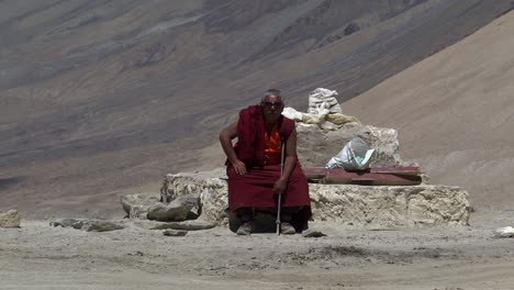 Einsamer-Nepalesischer-Mönch-Sitzt-Auf-Den-Geländefelsen-Des-Himalaya,-Weitwinkelaufnahme