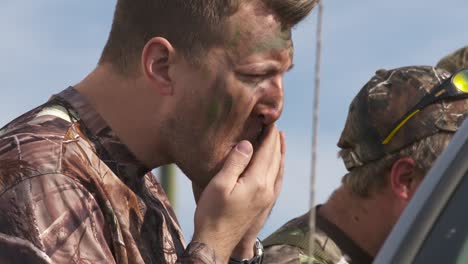 Close-up-of-duck-hunter-applying-camouflage-face-paint-before-hunting