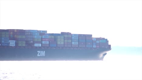 Large-Container-Ship-Traveling-across-sunny-body-of-water
