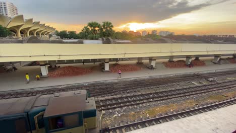 Desertic-Kamalapur-Railway-Station-with-a-Wagon-Slowly-Arriving,-in-Front-of-a-Cloudy-Sunset,-Bangladesh