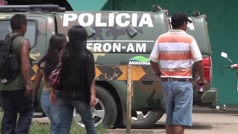 Menschen,-Die-In-Peru-An-Geparkten-Polizeilastwagen-Hinter-Einer-Absperrung-Vorbeigehen