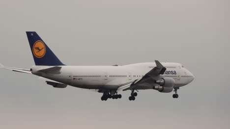 Airplane-of-German-company-Lufthansa-landing-in-a-grey-and-cloudy-sky