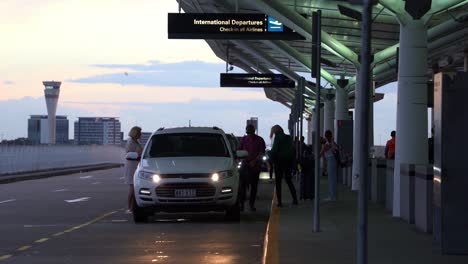 Parents-dropping-off-their-children-at-the-terminal-at-Brisbane-international-airport-in-early-morning,-static-shot
