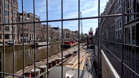 Blick-Auf-Bauverstärkungsarbeiten-Am-Amsterdamer-Kanal-Durch-Einen-Drahtzaun