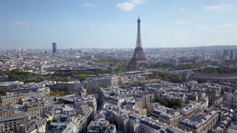 Aerial-cinematic-drone-Paris-France-Eiffel-Tower-from-a-distance-mid-day-late-summer-fall-romantic-blue-sky-surrounded-by-buildings-upward-reveal-pan-forward-motion