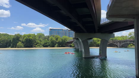 Kayakers-pass-under-a-bridge-on-lady-bird-lake-in-Austin-Texas