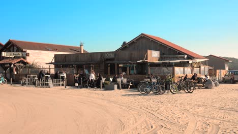 People-Relaxing-On-The-Beach-Bar-Near-Sand-Dunes-In-Les-Landes,-Atlantic-Coast,-France
