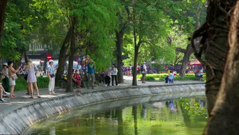 A-beautiful-corner-of-Hoan-Kiem-Lake-Public-Park-on-a-sunny-day-in-Hanoi-city-with-a-lot-of-people,-tourists-and-travelers-enjoying-the-holiday