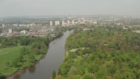 Slow-aerial-shot-along-the-Thames-river-between-Kew-Gardens-and-Hounslow