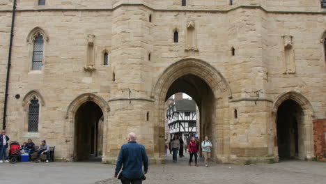 Archway-in-medieval-town-of-Lincoln-in-England-with-tourists-walking-through