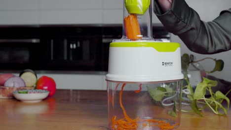 Carrot-pushed-into-powerful-food-chopper,-turns-into-thin-slices