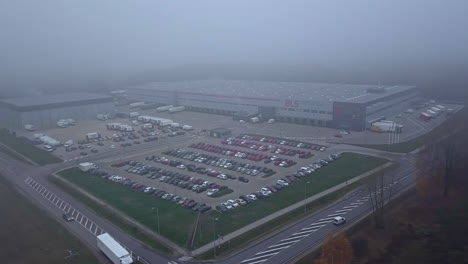 Aerial-view-of-large-BLS-Insdustries-warehouse,-Sweden,-foggy
