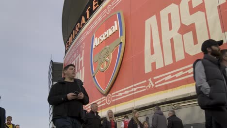 Arsenal-Fans-Gehen-Am-Spieltag-Unter-Dem-Arsenal-FC-Logo-Zum-Emirates-Stadion