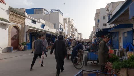 Establishing-shot-of-Bustling-street-in-Essaouira-with-market-stalls,-Morocco