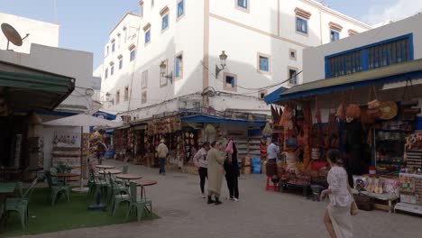 Establishing-shot-of-Bustling-street-corner-with-shops-in-the-medina,-Essaouira