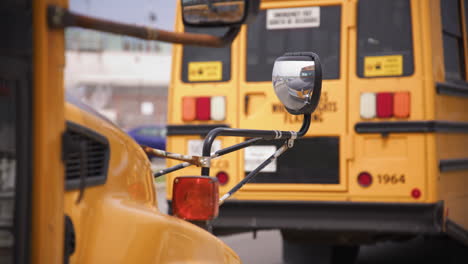 Yellow-school-bus-rack-focus---parked-in-front-of-school