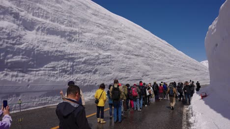 Touristen-Erkunden-Die-13-Meter-Hohe-Schneewand-In-Den-Tateyama-Bergketten