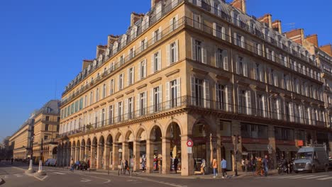 Impresionante-E-Icónico-Paisaje-De-La-Calle-En-El-Edificio-De-Arquitectura-Rue-De-Rivoli-Cerca-Del-Louvre-Con-Gente-Haciendo-Un-Recorrido-Durante-El-Día-En-París,-Francia