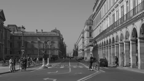 Paris,-France:-Black-and-white-shot-of-cars-moving-along-Rue-de-Rivoli-street-with-beautiful-arches-in-Central-Paris,-France-at-daytime