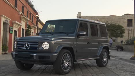 Modern-G-class-Mercedes-Benz-car-parked-in-middle-of-street-in-Oaxaca,-Mexico
