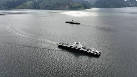 Electric-Car-Ferries-Eidsfjord-and-Gloppefjord-from-Fjord1-is-crossing-the-Nordfjord-sea-between-Anda-and-Lote-in-Norway---Aerial-showing-both-ferries-together