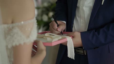 The-groom-is-signing-the-wedding-certificate-during-wedding-ceremony