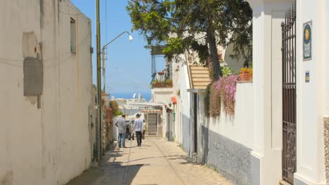 People-Strolling-On-Narrow-Street-Of-Anacapri-With-View-Of-The-Bay-Of-Naples-In-Italy
