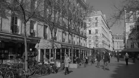 Paris,-France:-Black-and-white-shot-of-locals-walking-through-Chatelet-district-in-Paris,-France-on-a-sunny-day