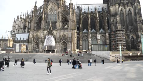 People-Walking-Across-Station-Forecourt-With-Cologne-Cathedral-In-Background