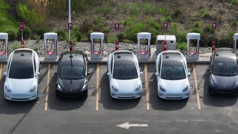 Aerial-truck-shot-of-Tesla-electric-vehicles-charging-at-Supercharger-station