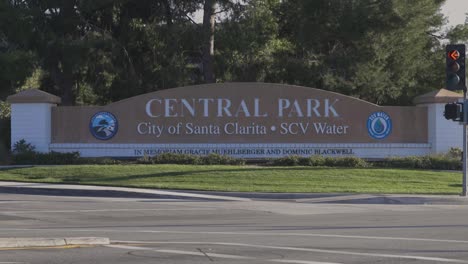 Static-real-time-shot-of-the-City-of-Santa-Clarita's-Central-Park-sign-that-memorializes-Gracie-Muehlberger-and-Dominic-Blackwell-the-two-Saugus-High-School-shooting-victims-as-traffic-passes-by