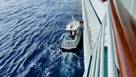 In-the-middle-of-the-vast-ocean,-captivating-sight-unfolds-as-an-officer-transfers-from-cruise-ship-to-a-pilot-boat