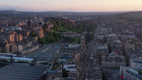 Wide-aerial-drone-shot-over-downtown-Edinburgh-at-sunset