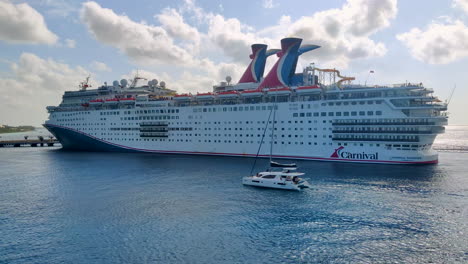 Experience-the-captivating-scene-of-two-Carnival-cruise-ships-majestically-docked-at-the-port,-while-a-luxurious-yacht-gracefully-passes-by-|-immersing-in-the-allure-of-both-cruise-ship-and-yacht