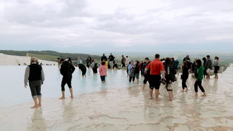 Crowds-of-visitors-to-Pamukkale-walk-barefoot-in-natural-hot-springs-attraction