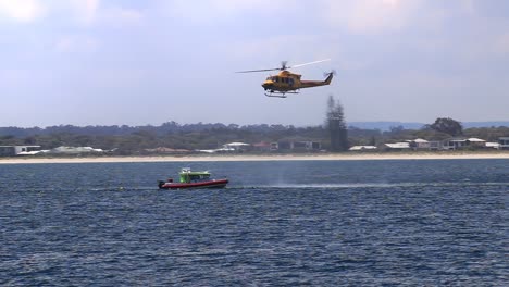 Rescue-Helicopter-Circling-Around-Stationary-Marine-Rescue-Boat-In-Geographe-Bay,-Busselton