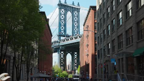 Manhattan-Bridge-between-Manhattan-and-Brooklyn-over-East-River-seen-from-a-narrow-alley-enclosed-by-two-brick-buildings-on-a-sunny-day-in-Washington-street-in-Dumbo,-Brooklyn,-NYC