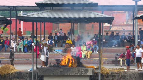 Mann-Schürt-Feuerbestattung-Im-Pashupatinath-Tempel-In-Kathmandu