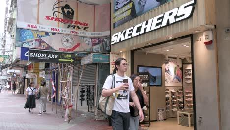 Chinese-customers-are-seen-at-the-American-lifestyle-and-performance-footwear-brand-Skechers-store-as-pedestrians-walk-past-it