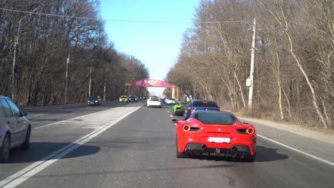 Zeitlupenaufnahme-Eines-Roten-Ferrari,-Eines-Grünen-Lamborghini-Und-Eines-Blauen-BMW-Auf-Der-Straße