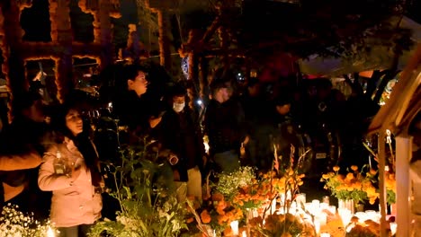 People-celebrating-the-day-of-the-dead-in-a-Mexican-cemetery-in-Tzintzuntzan,-Michoacán,-Mexico,-one-of-the-most-representative-to-celebrate-the-day-of-the-dead