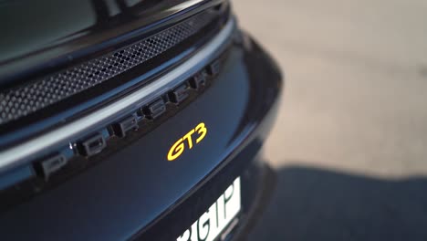Pan-close-up-shot-of-Porsche-GT3-sign-and-rear-bumper