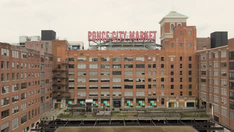 Aerial-pull-back-wide-exterior-shot-of-the-Ponce-City-Market,-a-vibrant-converted-historic-Sears-building,-now-a-market-with-a-food-hall,-shops-and-living-space