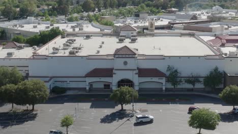 Aerial-static-shot-of-an-empty-mall-building-where-a-Sears-store-closed-down-and-the-mall-building-remains-vacant-with-very-few-cars-occupying-the-parking-lot