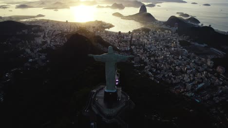 Flying-past-the-Christ-statue-overlooking-Rio-city,-sunset-in-Brazil---Aerial-view