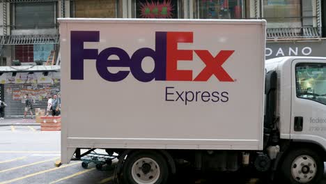 Fußgänger-Gehen-An-Einem-FedEx-Lastwagen-Des-Amerikanischen-Lieferservices-Und-Logistikunternehmens-Vorbei,-Der-Auf-Der-Straße-Von-Hongkong-Stationiert-Ist
